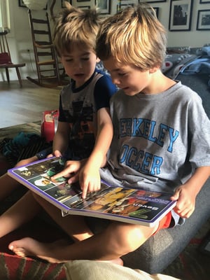 two boys reading a book together