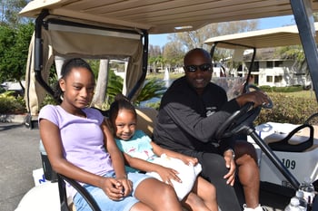 Anddrikk Frazier in golf cart with his daughters at Tampa Prep Golf Outing