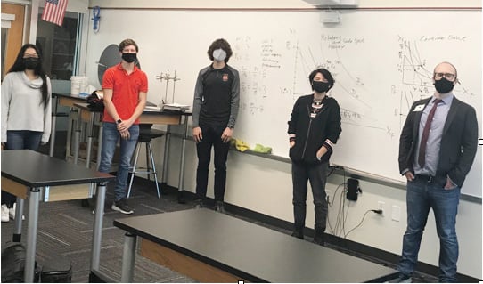 Tampa Prep Calculus III students stand in class to learn from a University of Tampa professor.